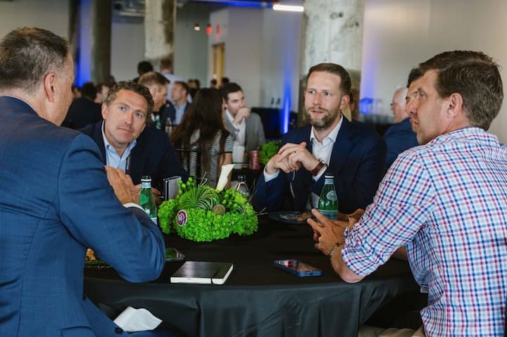 Attendees in conversation at a round table during the summit